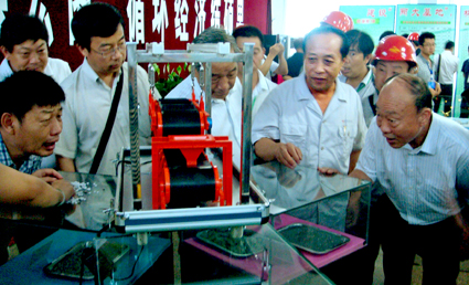 鞍钢矿渣开发公司经理苏兴文与参会代表关注钢渣带磁机演示